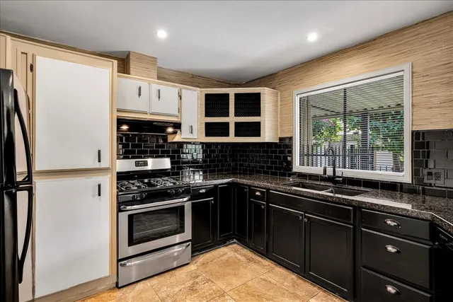 a kitchen with stainless steel appliances granite countertop a stove a sink and a microwave