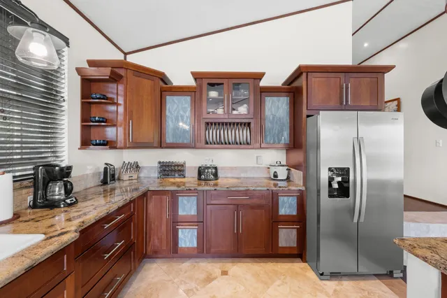 a kitchen with stainless steel appliances granite countertop a refrigerator a stove and a sink