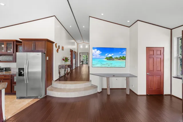 a view of a living room with stainless steel appliances with wooden floor