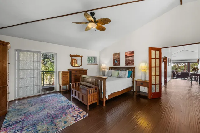 a bedroom with a bed bookshelf and a large window
