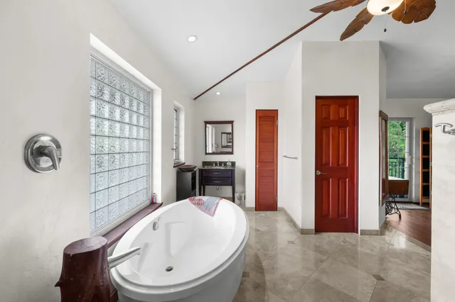 a bedroom with a bed chandelier and a window