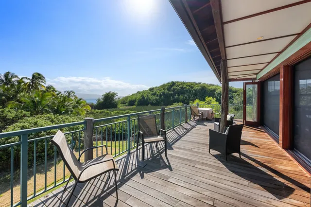 a balcony with wooden floor and outdoor seating