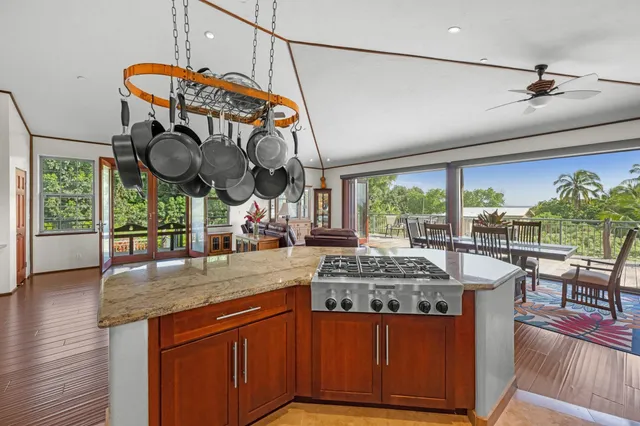 a kitchen with stainless steel appliances granite countertop a stove and large window