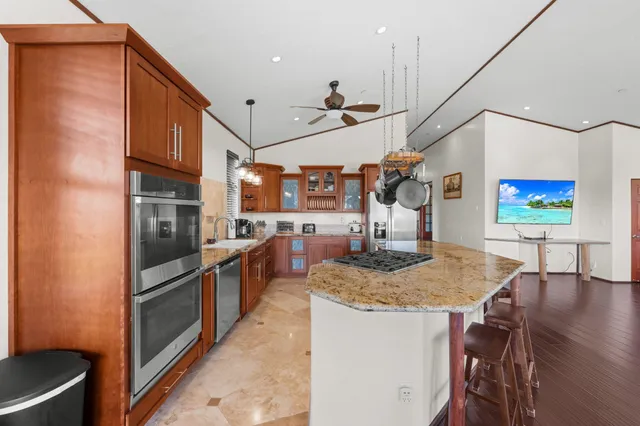 a kitchen with stainless steel appliances granite countertop a sink and a refrigerator