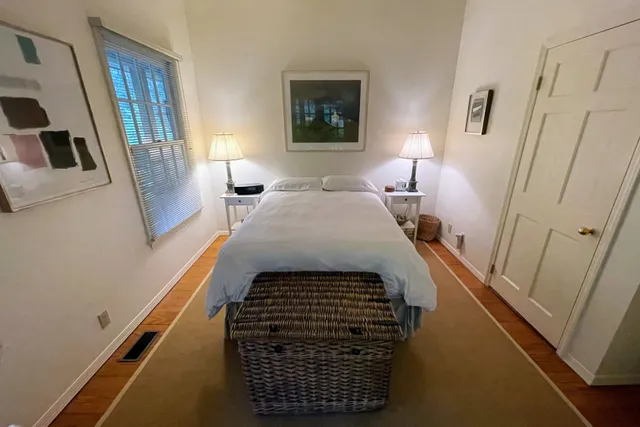 a bedroom with a bed and a flat tv screen on a dresser