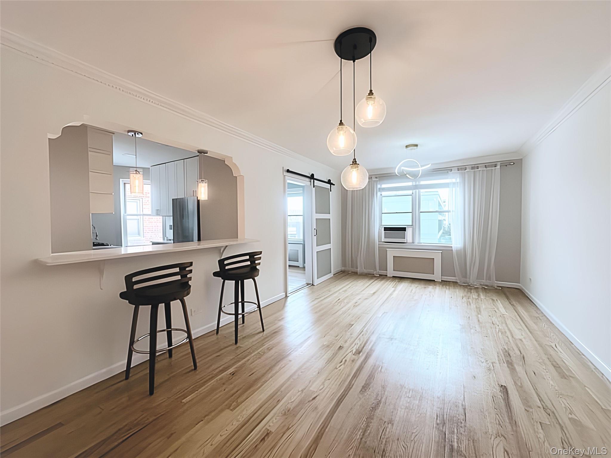 800 Grand Concourse, Unit 2JS Bronx, NY 10451 - Photo 2 of 18 a view of a room with wooden floor a chandelier a wooden table and chairs