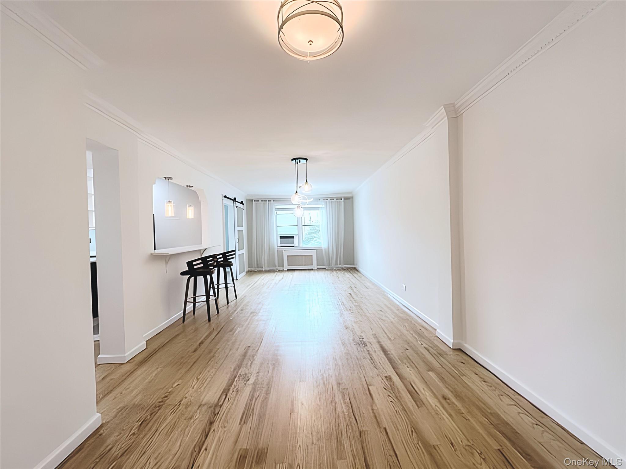 800 Grand Concourse, Unit 2JS Bronx, NY 10451 - Photo 3 of 18 wooden floor in an empty room with a window