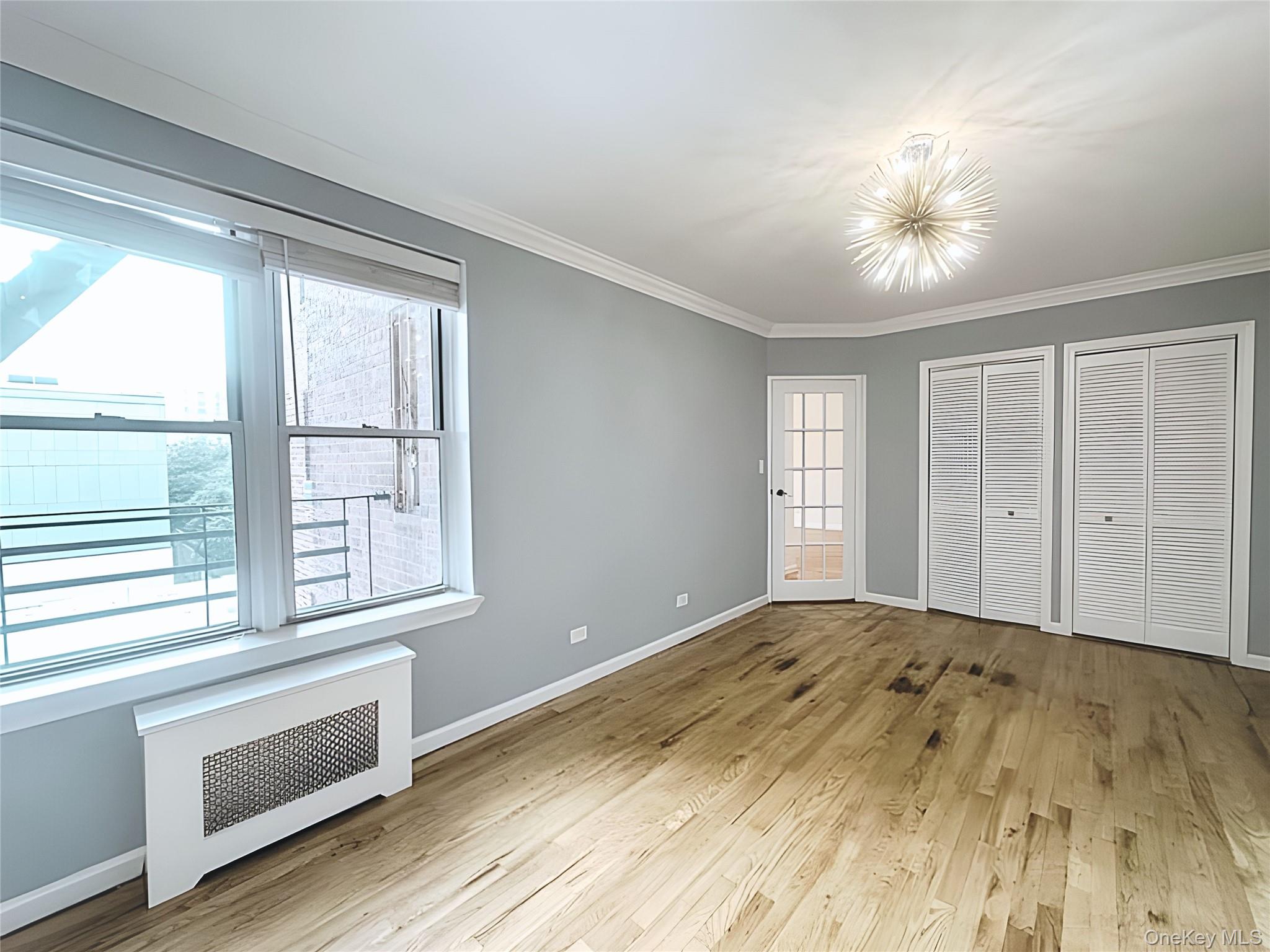 800 Grand Concourse, Unit 2JS Bronx, NY 10451 - Photo 10 of 18 a view of an empty room with wooden floor and a window