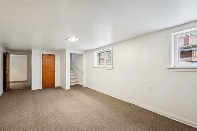 a view of an empty room with closet and a window