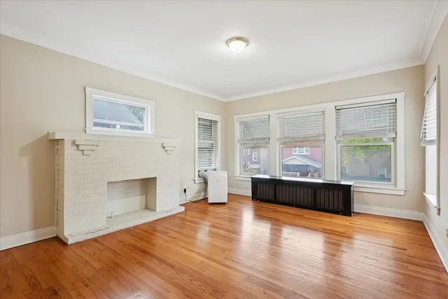 a view of empty room with a fireplace and wooden floor