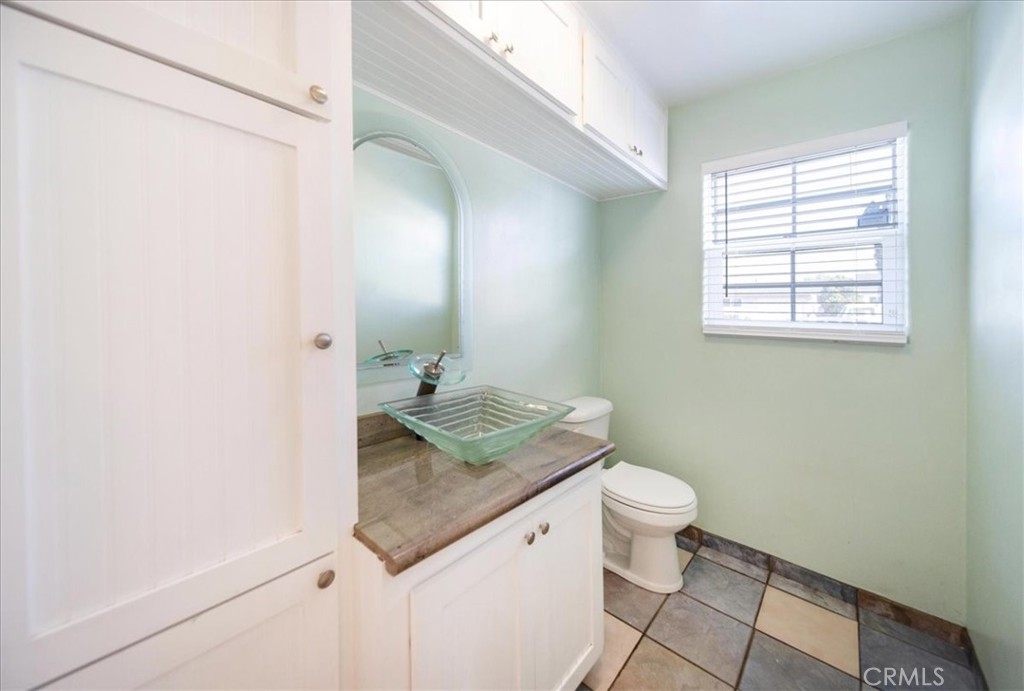 570 Emory Street Imperial Beach, CA 91932 - Photo 34 of 43 a bathroom with a granite countertop sink a toilet and a mirror