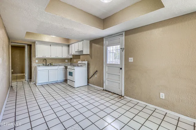 a kitchen with a sink a stove and cabinets