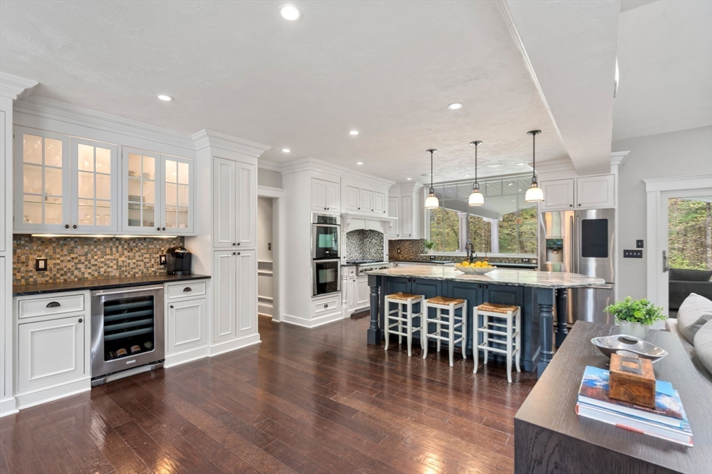 358 Cartwright Road Needham, MA 02492 - Photo 7 of 35 a kitchen with stainless steel appliances granite countertop a stove top oven a sink dishwasher a dining table and chairs with wooden floor