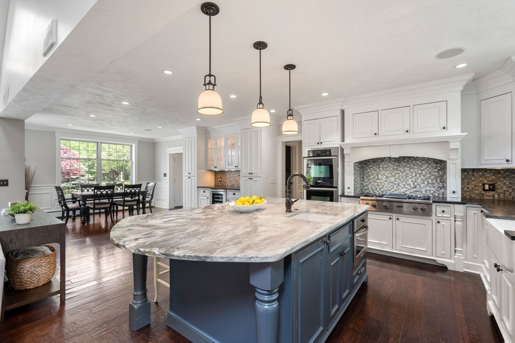 358 Cartwright Road Needham, MA 02492 - Photo 8 of 35 a kitchen with granite countertop a stove a sink a center island and chairs