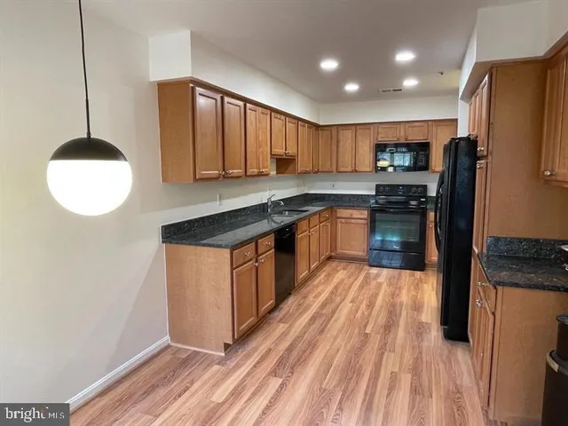 a kitchen with stainless steel appliances granite countertop a stove a sink dishwasher and a refrigerator