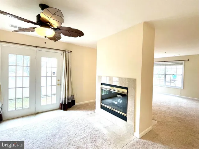 a view of an empty room with a fireplace and a window