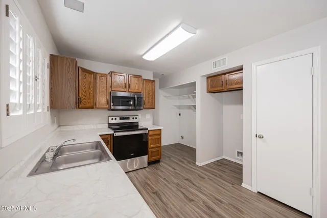 a kitchen with wooden floors and stainless steel appliances