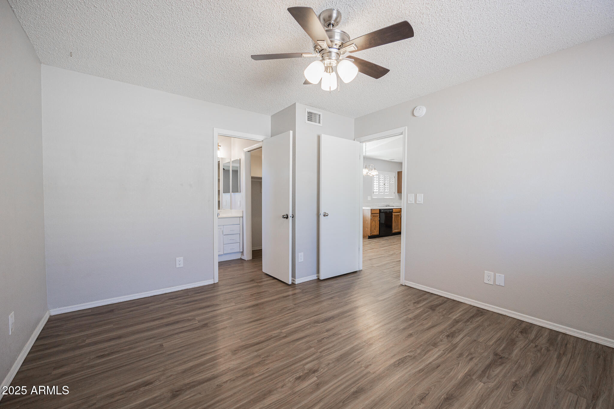 619 East Jensen Street, Unit 42 Mesa, AZ 85203 - Photo 14 of 24 an empty room with wooden floor and ceiling fan