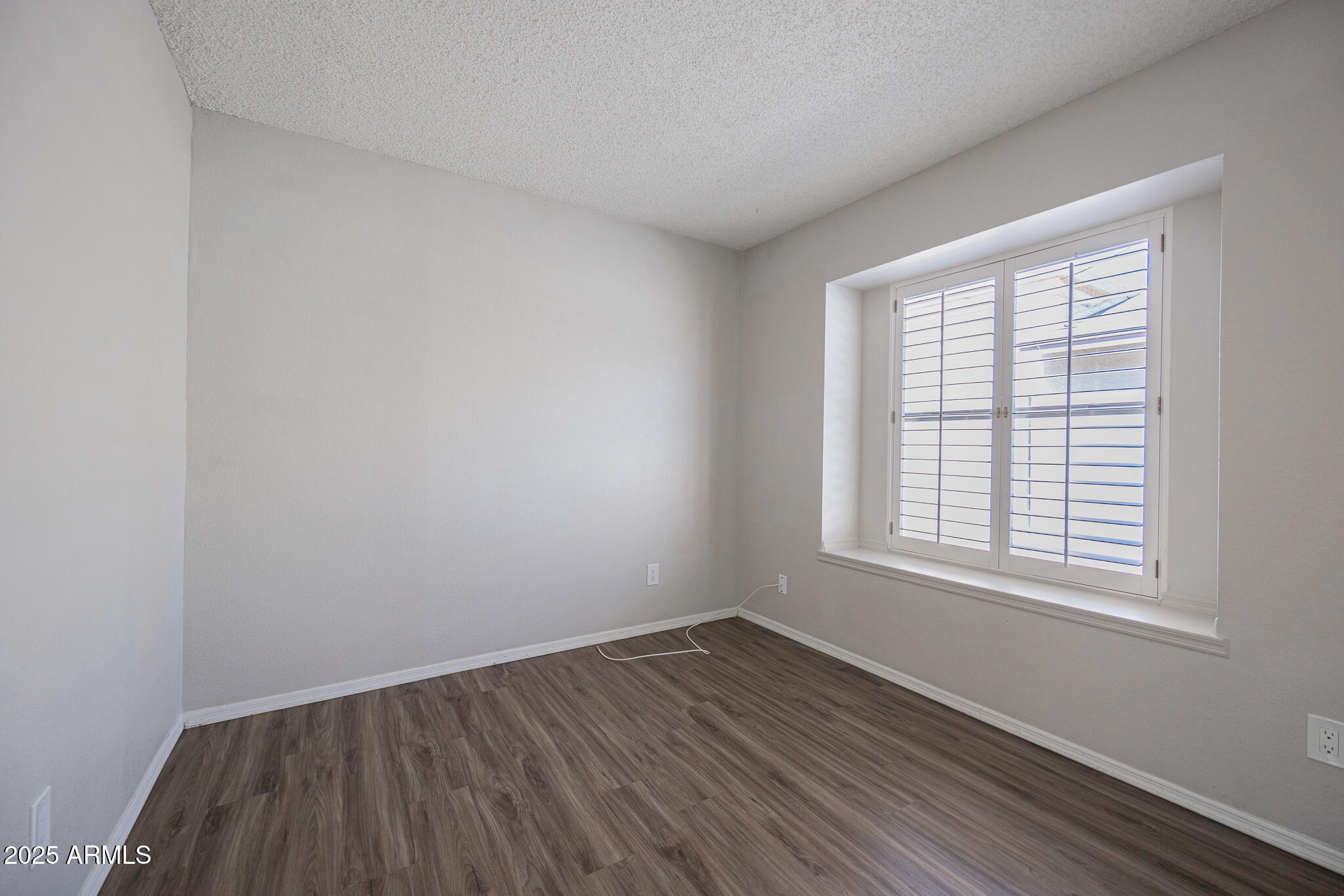 619 East Jensen Street, Unit 42 Mesa, AZ 85203 - Photo 19 of 24 an empty room with wooden floor and windows