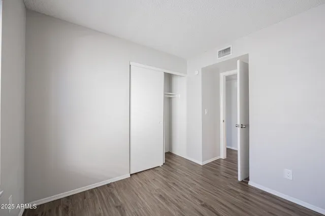 a view of an empty room with wooden floor