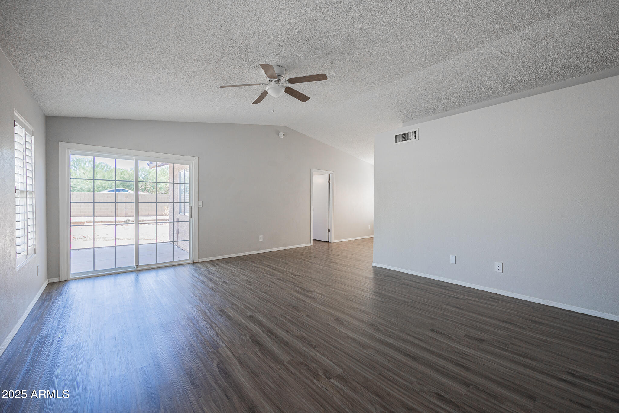 619 East Jensen Street, Unit 42 Mesa, AZ 85203 - Photo 4 of 24 a view of an empty room with wooden floor and a window
