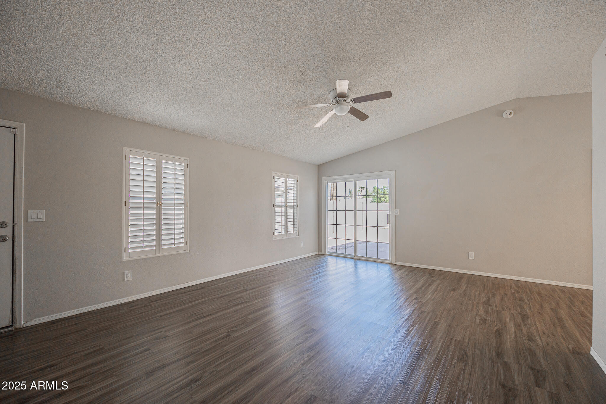 619 East Jensen Street, Unit 42 Mesa, AZ 85203 - Photo 7 of 24 an empty room with wooden floor and windows