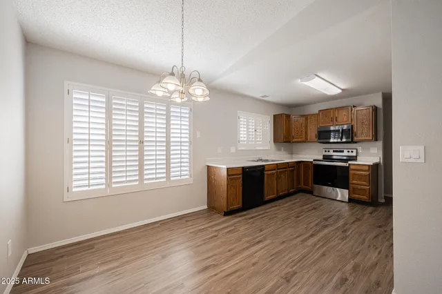 a large kitchen with a large counter top a sink stainless steel appliances and cabinets