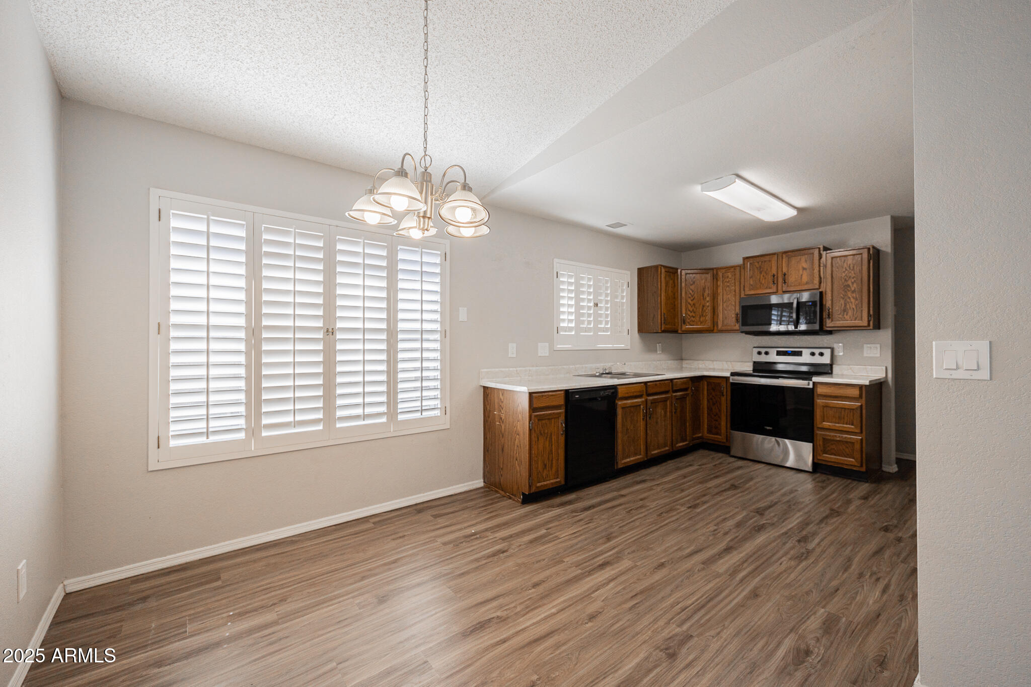619 East Jensen Street, Unit 42 Mesa, AZ 85203 - Photo 8 of 24 a large kitchen with a large counter top a sink stainless steel appliances and cabinets