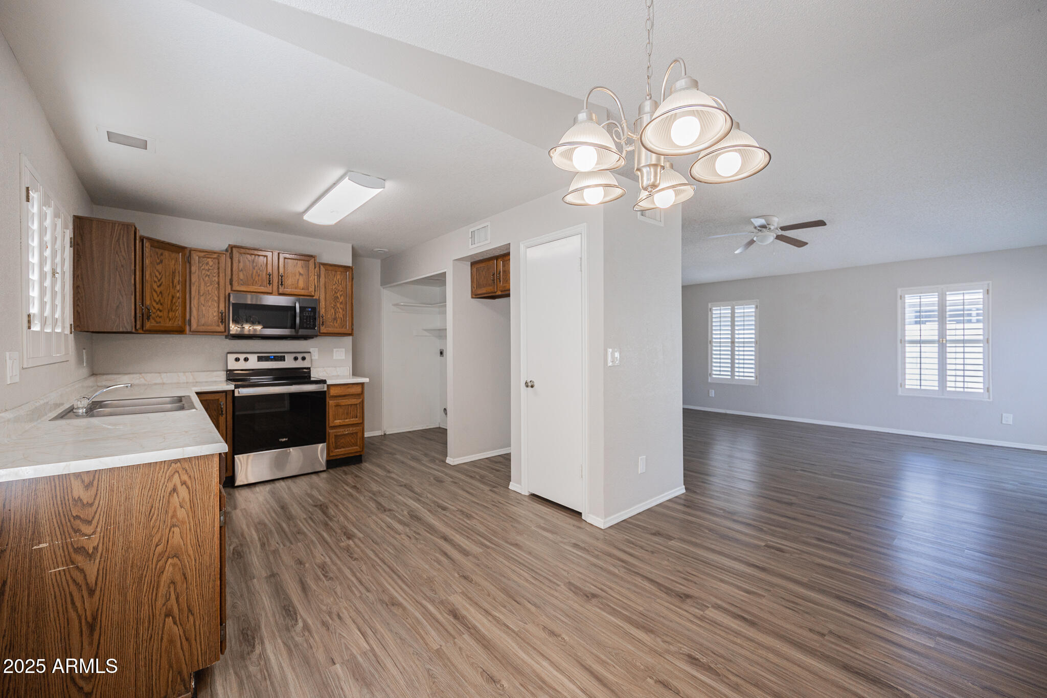 619 East Jensen Street, Unit 42 Mesa, AZ 85203 - Photo 9 of 24 a kitchen with granite countertop wooden floors a center island stainless steel appliances and cabinets