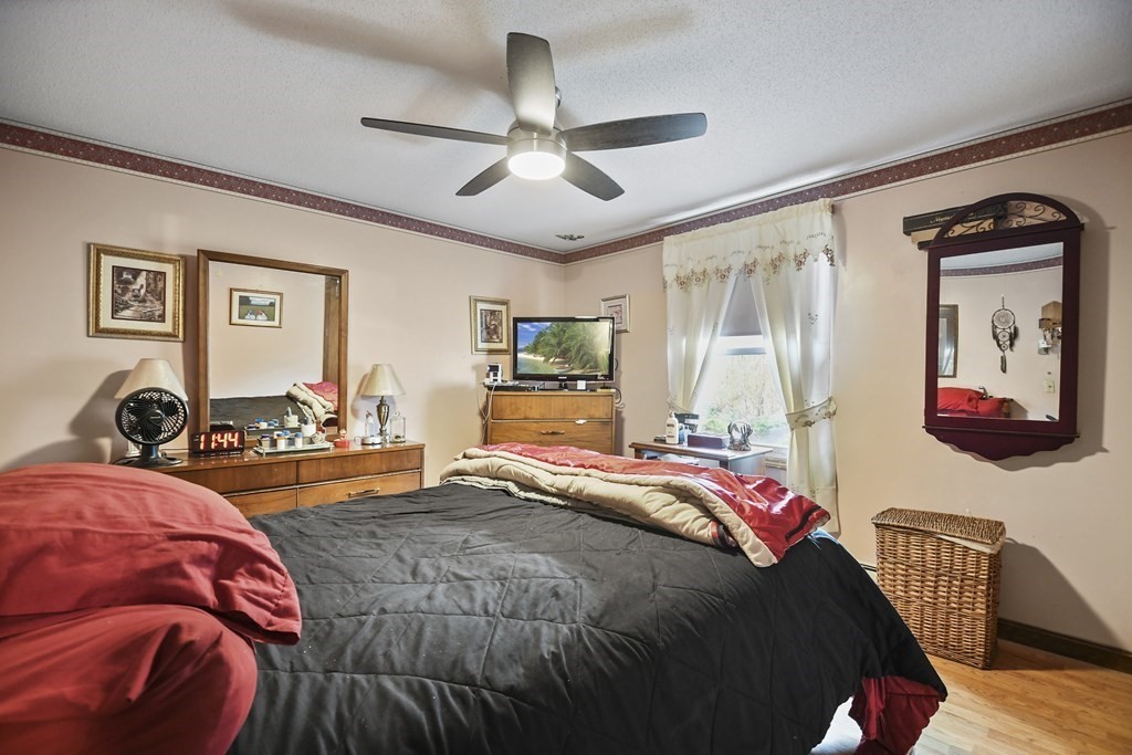 279 Little Alum Road Brimfield, MA 01010 - Photo 12 of 37 a bedroom with a bed and dresser with wooden floor