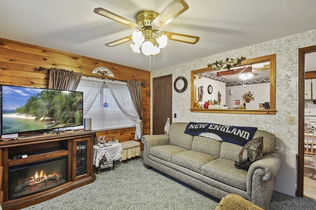 279 Little Alum Road Brimfield, MA 01010 - Photo 4 of 37 a living room with furniture a ceiling fan and a fireplace