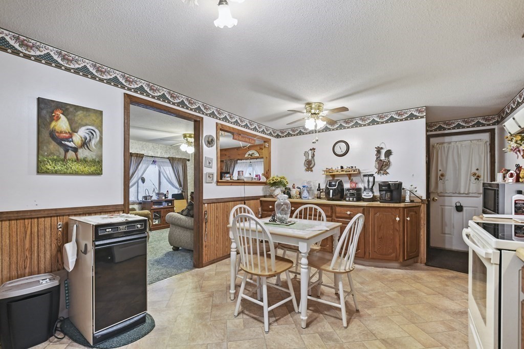 279 Little Alum Road Brimfield, MA 01010 - Photo 8 of 37 a kitchen with stainless steel appliances granite countertop a stove top oven a sink a dining table and chairs with wooden floor
