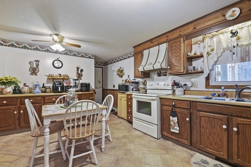 279 Little Alum Road Brimfield, MA 01010 - Photo 9 of 37 a kitchen with stainless steel appliances granite countertop a stove a sink dishwasher and cabinets with wooden floor