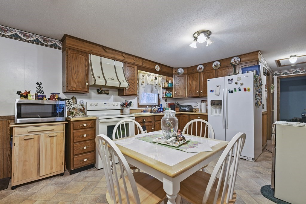 279 Little Alum Road Brimfield, MA 01010 - Photo 10 of 37 a kitchen with refrigerator cabinets and a table
