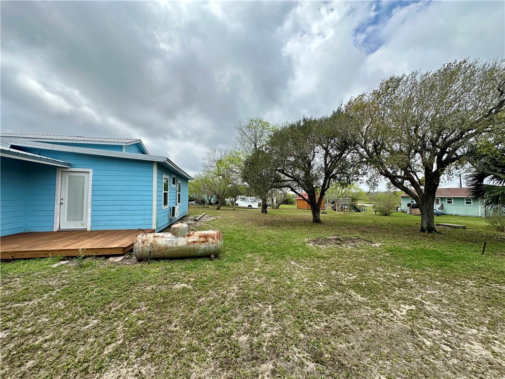 323 Copano Bayside, TX 78340 - Photo 19 of 22 a backyard of a house with large trees and outdoor seating