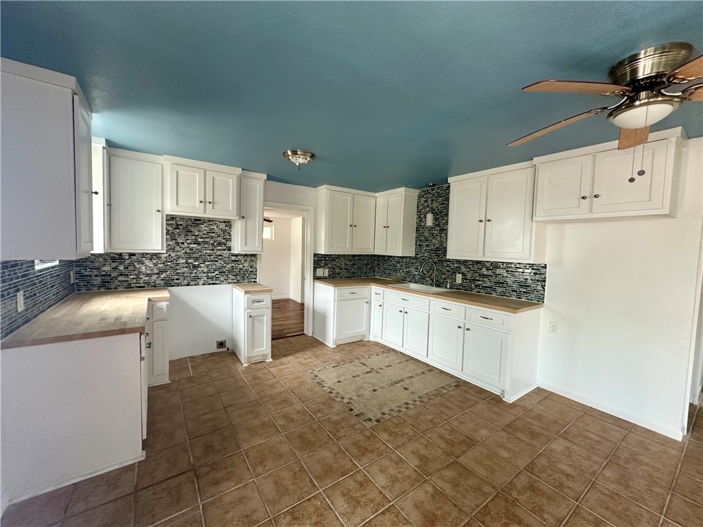 323 Copano Bayside, TX 78340 - Photo 6 of 22 a kitchen with granite countertop a sink stove and white cabinets