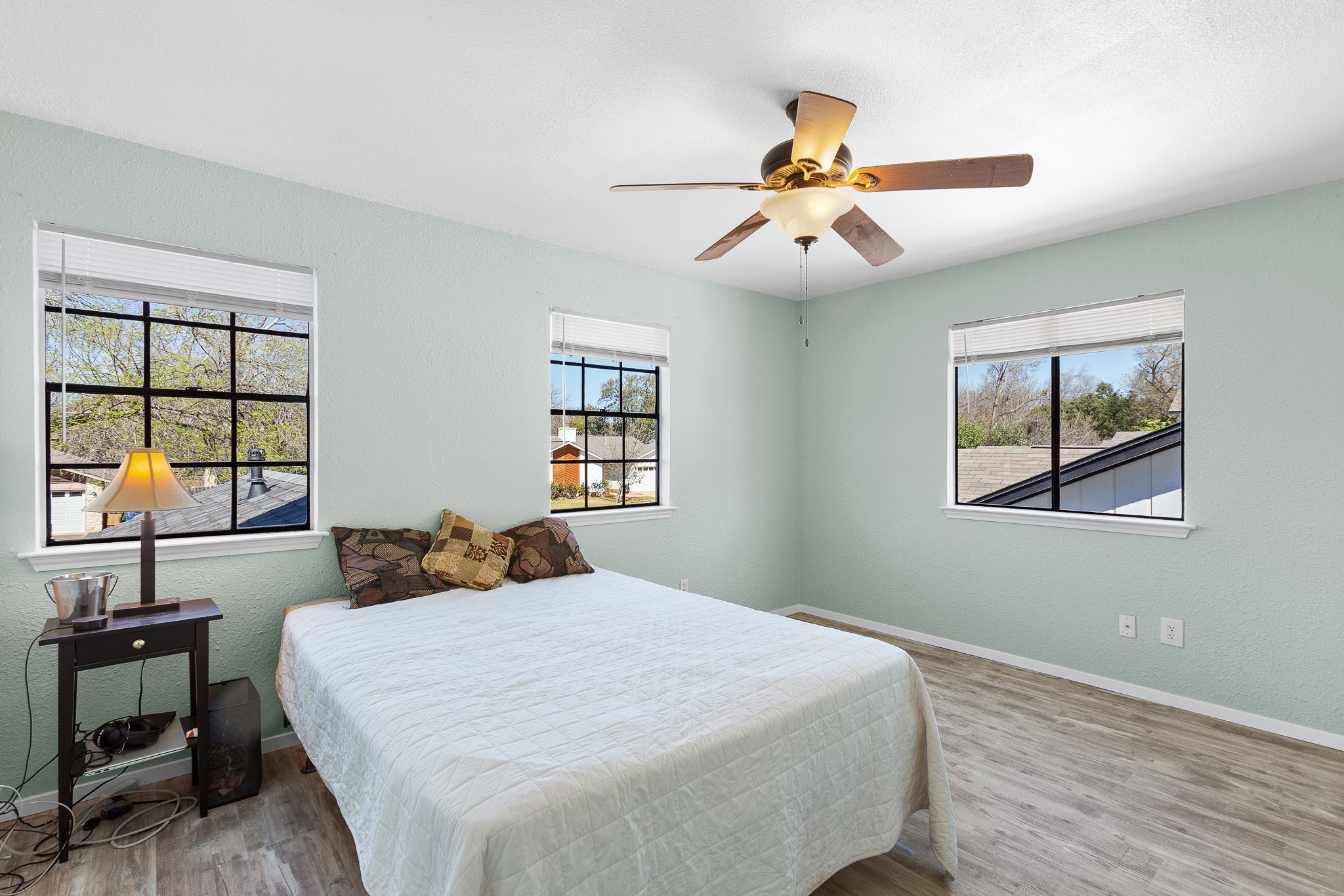 8007 Swindon Lane Austin, TX 78745 - Photo 21 of 27 Bedroom featuring light wood-type flooring, a ceiling fan, and a textured wall