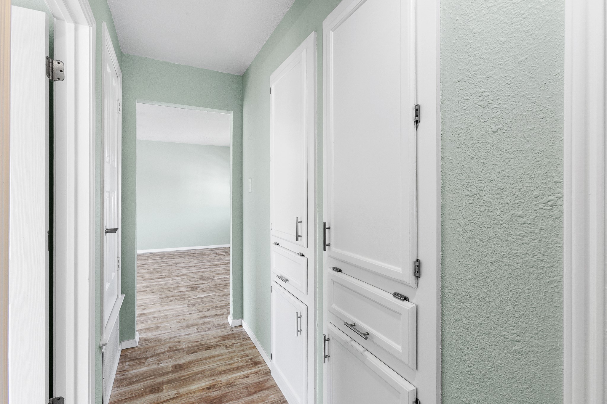 8007 Swindon Lane Austin, TX 78745 - Photo 23 of 27 Hallway with light wood-type flooring and a textured wall
