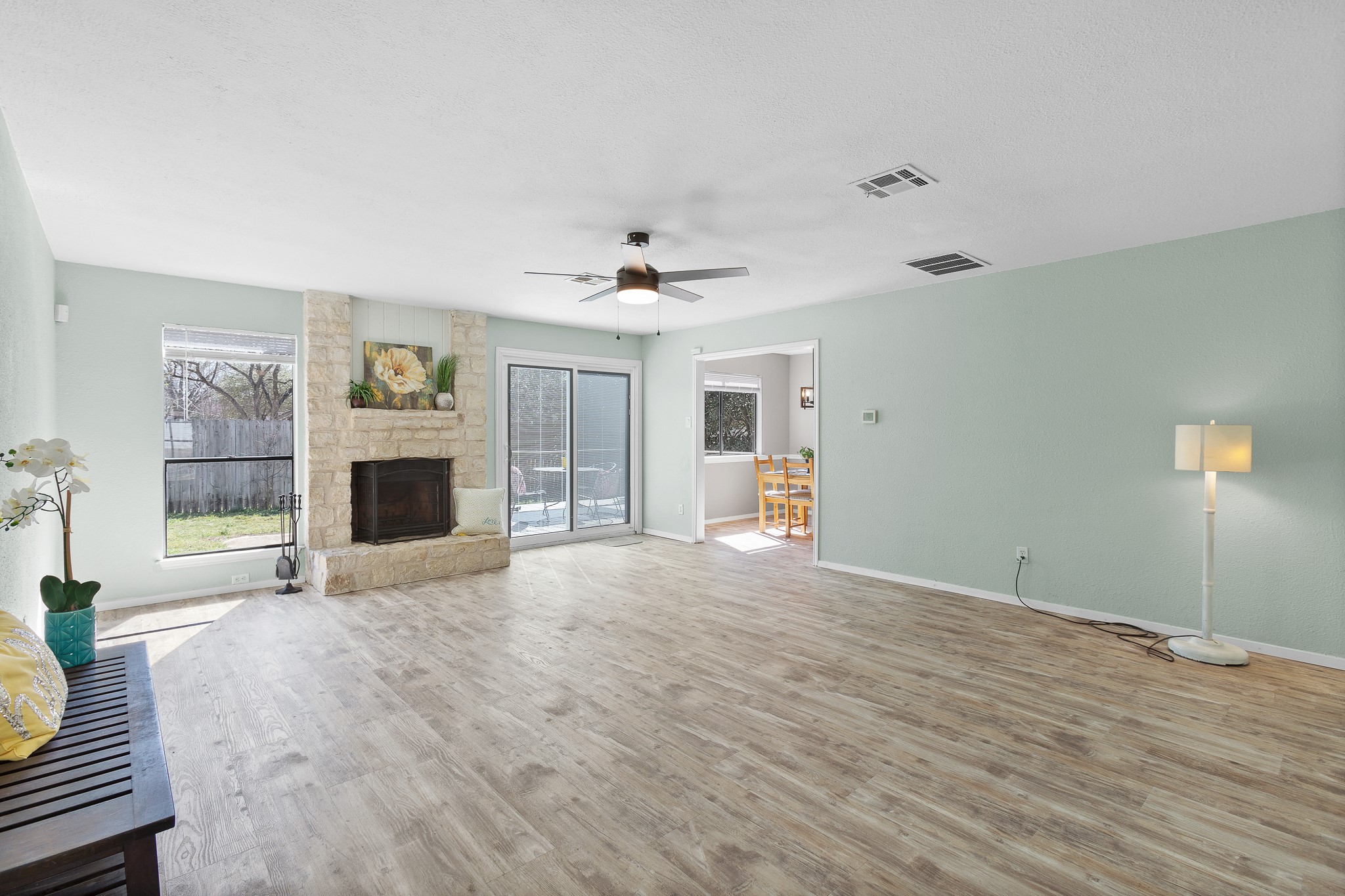 8007 Swindon Lane Austin, TX 78745 - Photo 4 of 27 Living room featuring vinyl flooring, and a stone fireplace open to the breakfast room