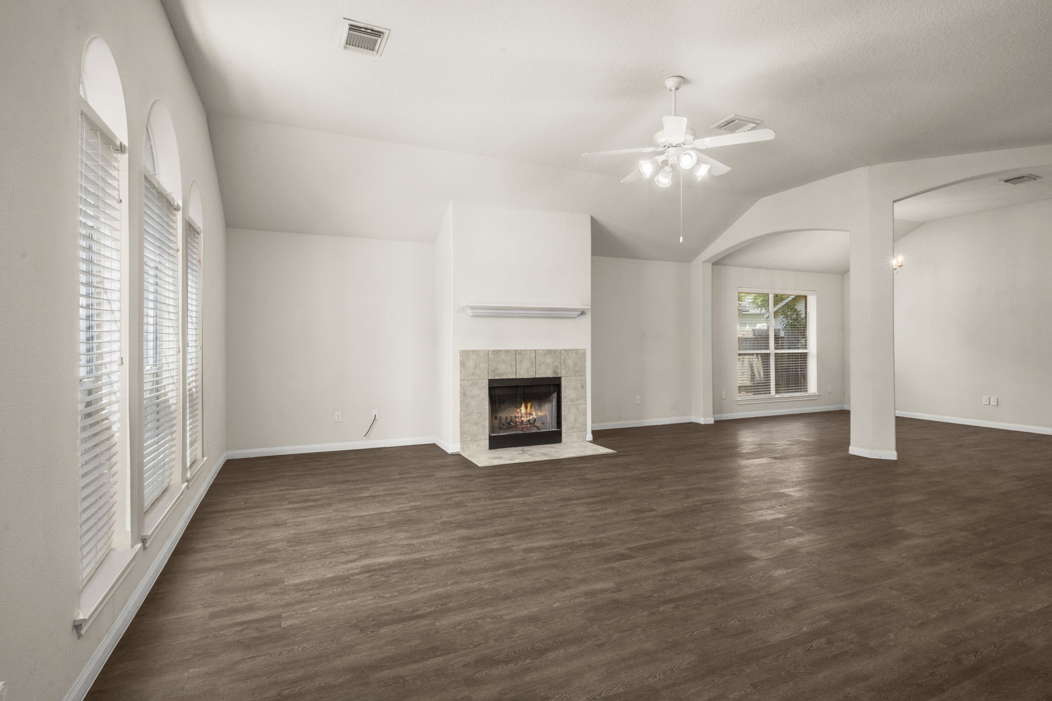 3226 Woodwind Road Montgomery, TX 77356 - Photo 6 of 34 an empty room with wooden floor fireplace and windows