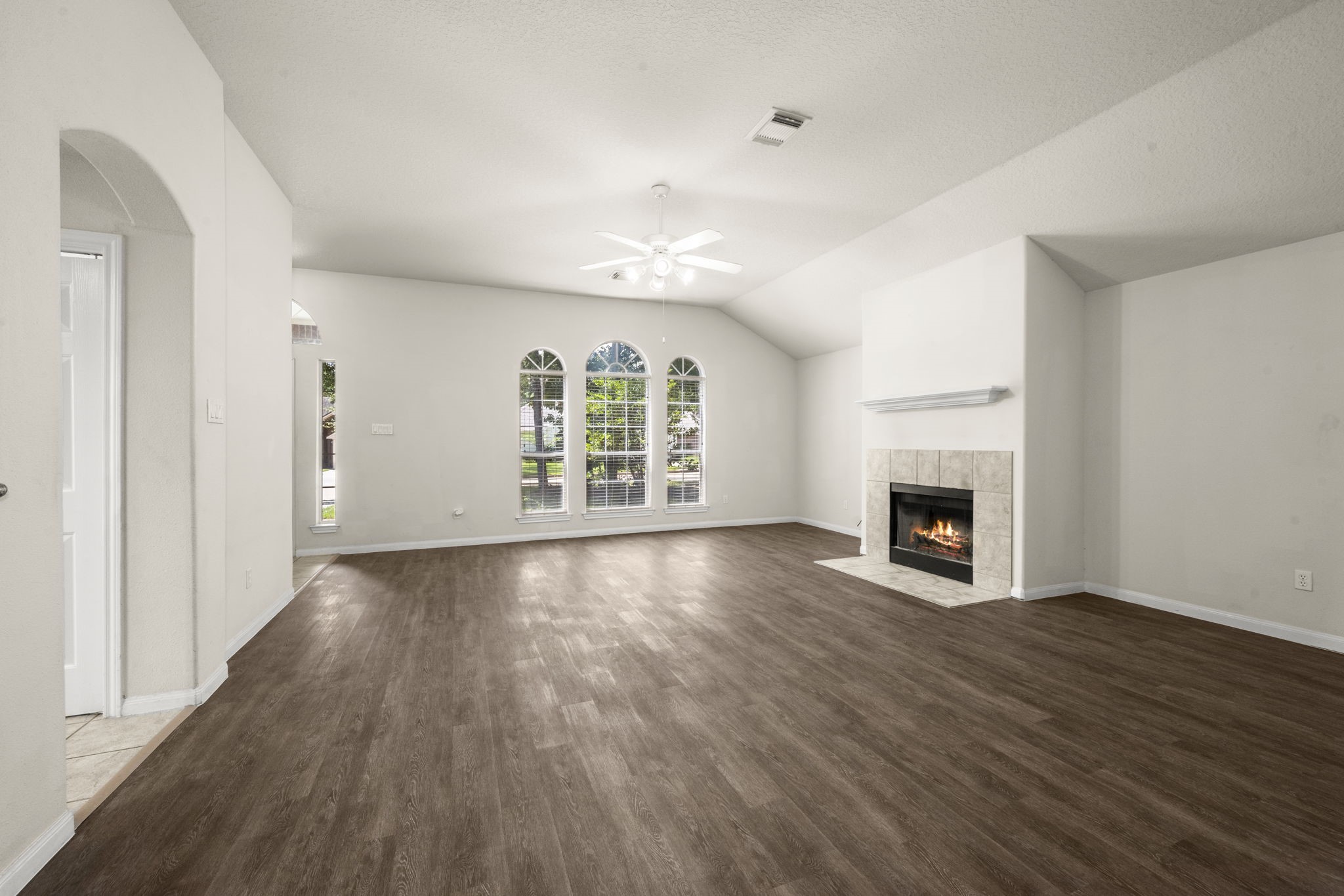 3226 Woodwind Road Montgomery, TX 77356 - Photo 10 of 34 an empty room with windows a fireplace and wooden floor