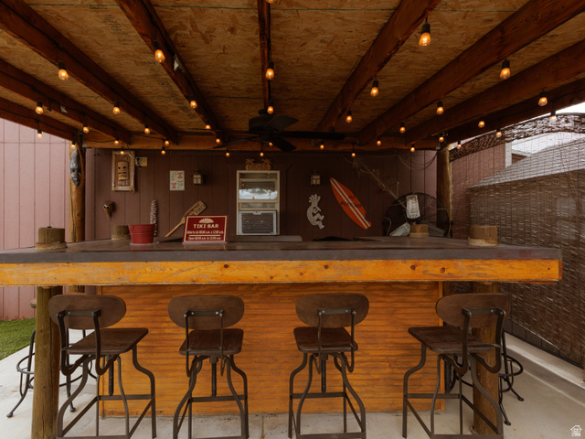 8252 Wood Street Midvale, UT 84047 - Photo 26 of 40 Covered outdoor bar area featuring string lighting, a corrugated metal bar front, and a built-in outdoor air conditioning unit