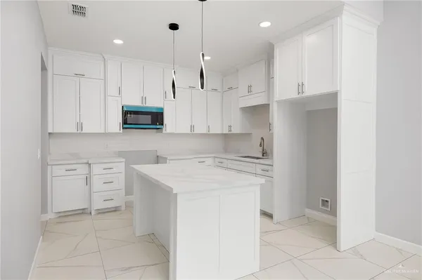 a kitchen with white cabinets and white appliances