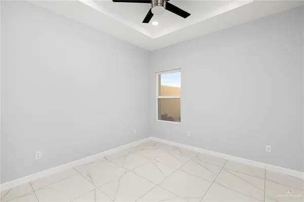 an empty room with a ceiling fan and window