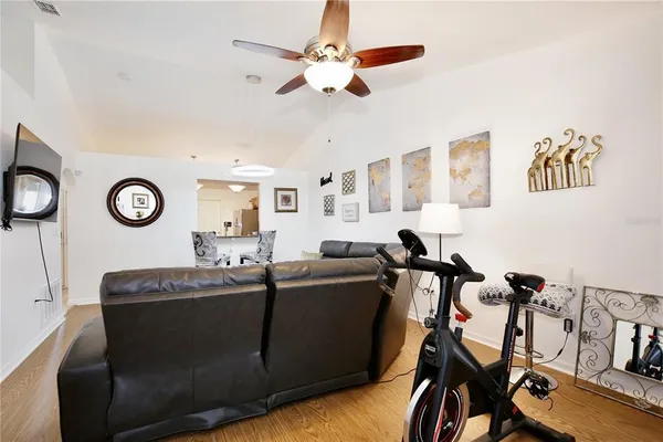 a living room with furniture a clock and a ceiling fan