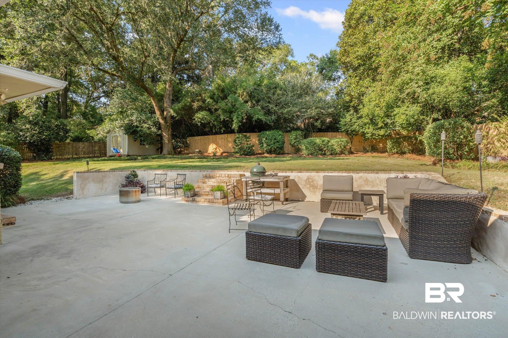 313 Brawood Drive Mobile, AL 36608 - Photo 26 of 32 Fenced backyard with a patio area, outdoor lounge area, and view of scattered trees