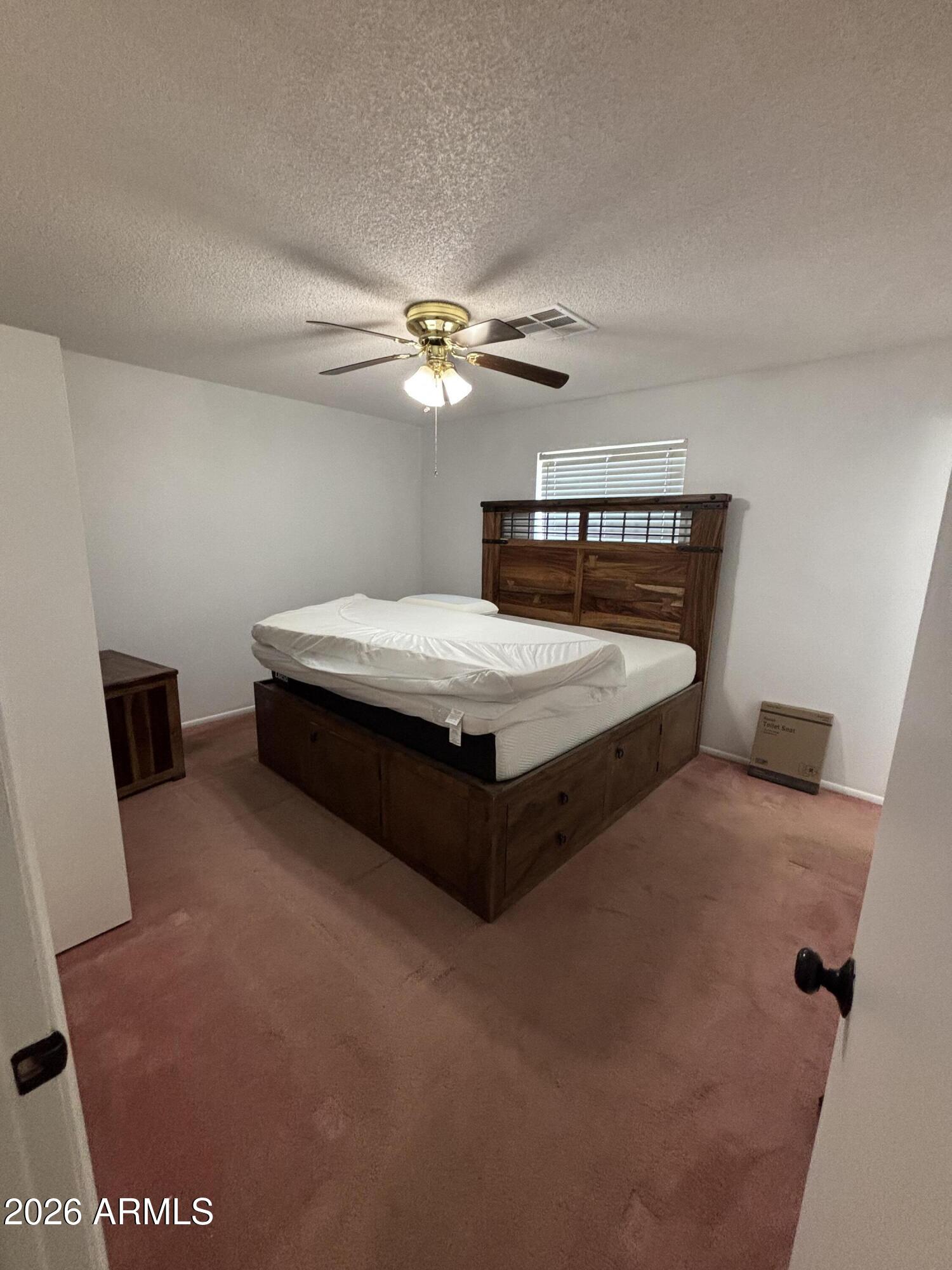 6508 West Fremont Road Laveen, AZ 85339 - Photo 15 of 32 a spacious bedroom with a bed and a chandelier
