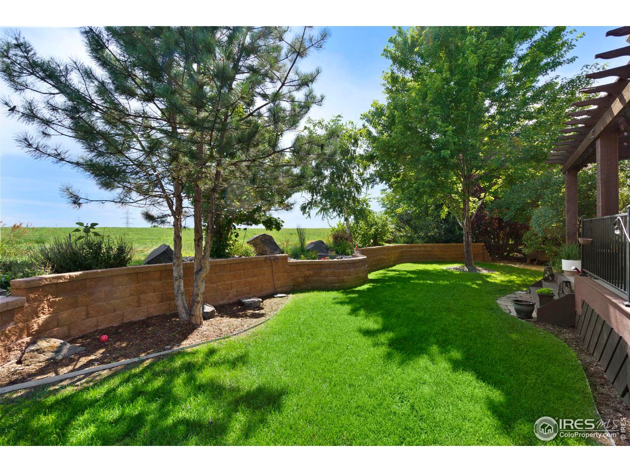 7702 Plateau Road Greeley, CO 80634 - Photo 34 of 40 Mature Trees, Manicured Landscape, Retaining Wall with Planted Shrubs & Trees!