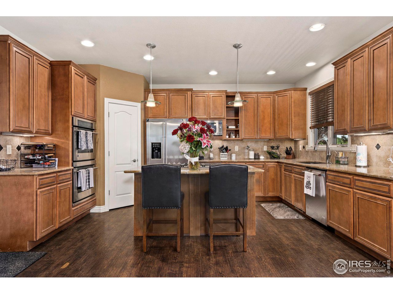 7702 Plateau Road Greeley, CO 80634 - Photo 6 of 40 Gourmet Kitchen with Plenty of Cabinet Space & Pantry Storage, SS Appliances, Double Ovens & Gas Range!