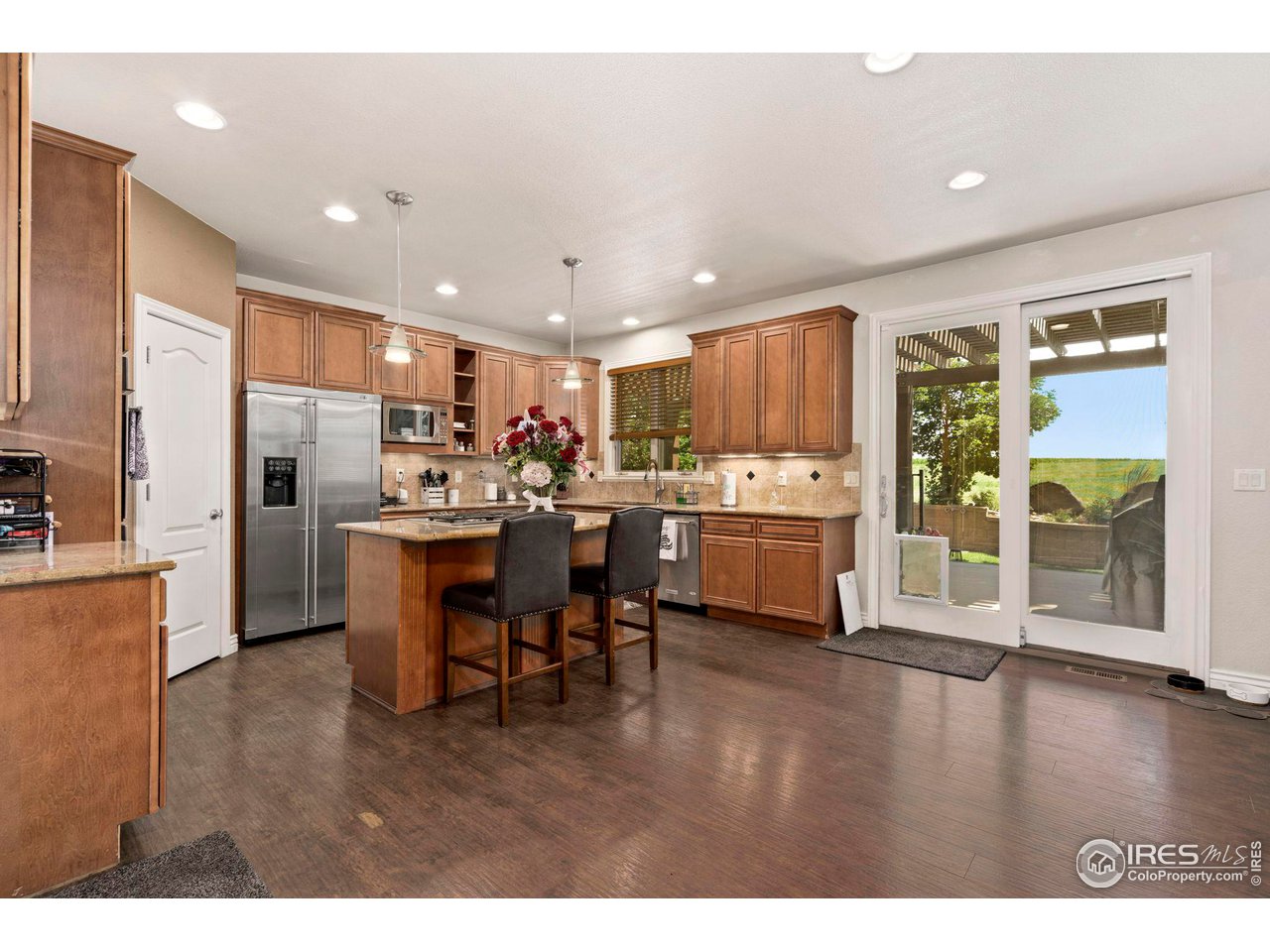 7702 Plateau Road Greeley, CO 80634 - Photo 7 of 40 Kitchen Island, Breakfast Nook, Views to the Back, Slider Opens to Large Back Trex Deck Overlooking Private Farm Land!